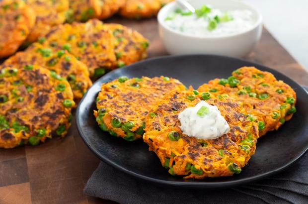 Carrot-Pea Fritters on a plate with a dollop of raita