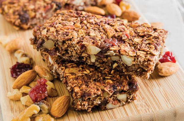 Stacked Chewy Cocoa Granola Bars on a cutting board