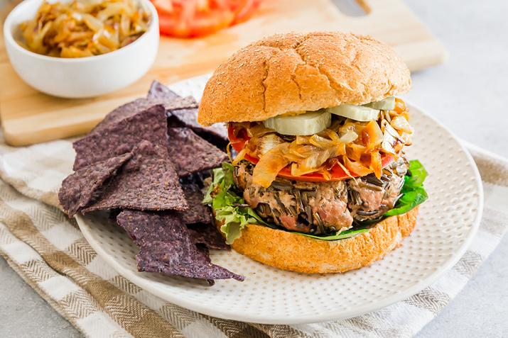 Wild Rice Beef Burger plated with blue tortilla chips on the side