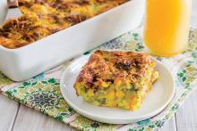 Square of vegetable egg bake on a plate next to casserole dish